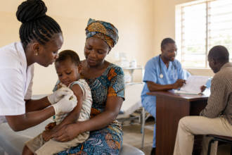 Healthcare workers providing hepatitis vaccination and medical consultation at a community clinic in Africa