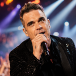 Robbie Williams performing live, representing his best-known songs and solo hits